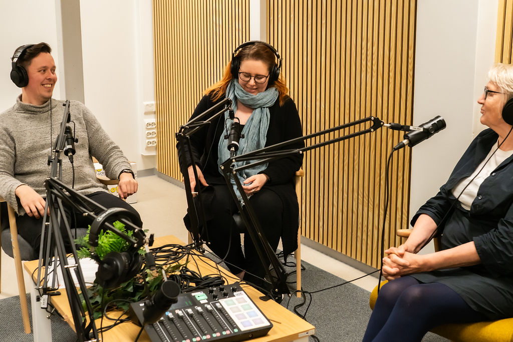 Kolme ihmistä tekemässä podcastia studiossa